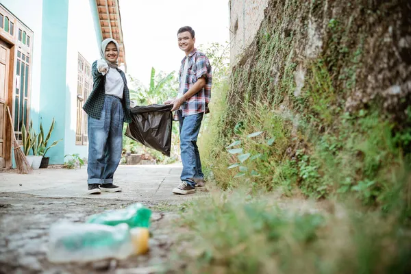 Dois voluntários adolescentes felizes pegando lixo — Fotografia de Stock