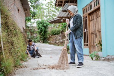 İki mutlu gönüllü genç çöpleri topluyor.