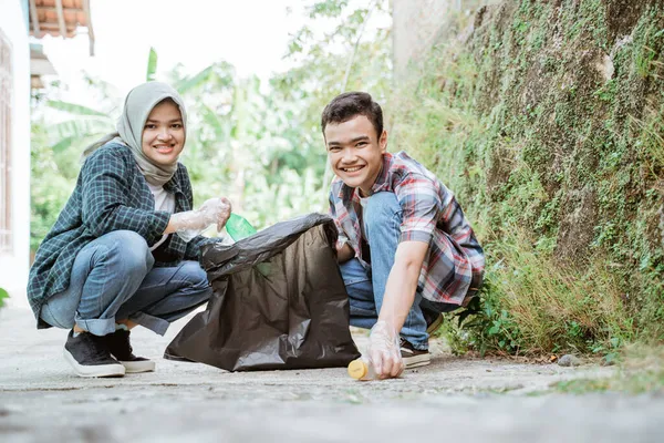 Two happy teenage volunteers picking up trash — Stock Photo, Image