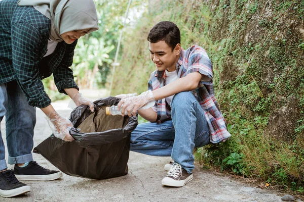 Two happy teenage volunteers picking up trash — Stock Photo, Image