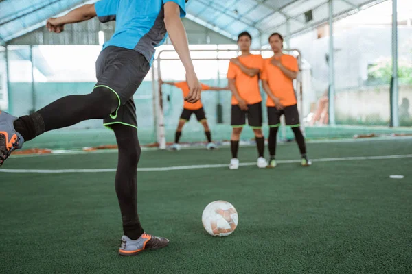 a futsal player takes a free kick