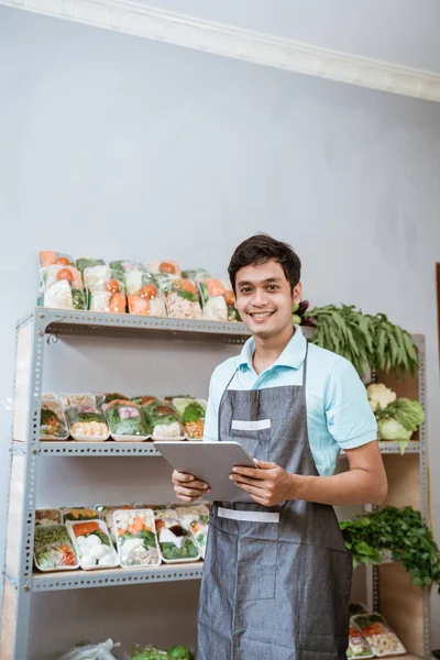 Asiático homem vendendo legumes sorrindo ao usar uma almofada — Fotografia de Stock