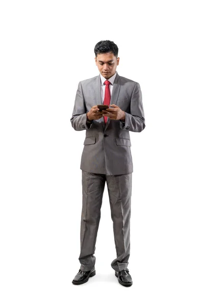 Ganzkörperporträt eines jungen asiatischen Geschäftsmannes mit Smartphone — Stockfoto