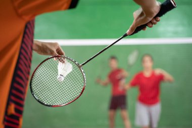 Badminton oyuncu bir raketle hizmet için hazır
