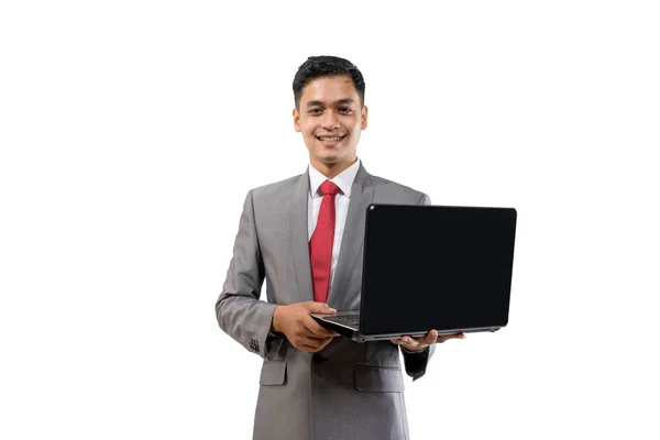 Negocios joven asiático hombre sosteniendo un portátil mientras de pie aislado sobre blanco — Foto de Stock