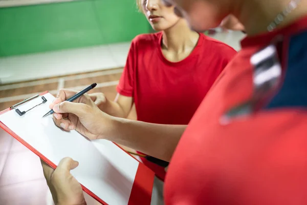 Coach gives instructions to players using pen and clipboard — Stock Photo, Image