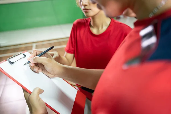 Coach donne des instructions aux joueurs en utilisant un stylo et presse-papiers — Photo