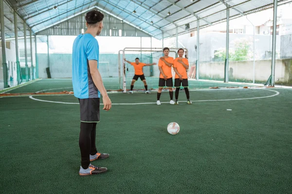 a futsal player prepares to take a free kick