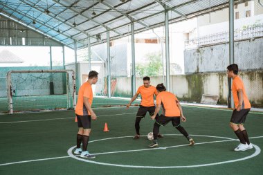 Futsal oynatıcı başka bir oyuncunun geçmesini engellemeye çalışır