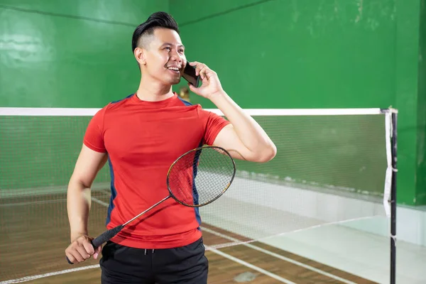 Badminton spelare i rött håller ett racket ringa ett samtal — Stockfoto