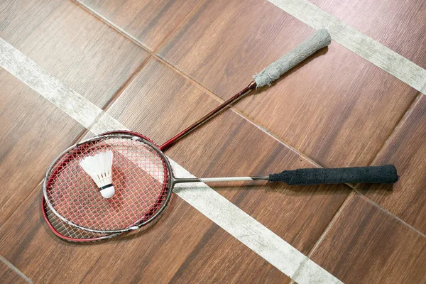 Due racchette e volantini sul pavimento del campo di badminton — Foto Stock