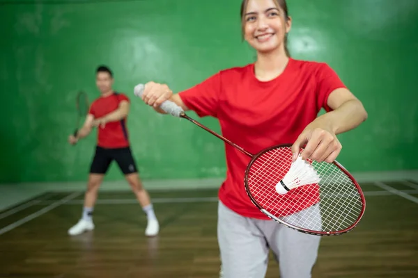 A shuttlecock is held by a female badminton player Stock Image