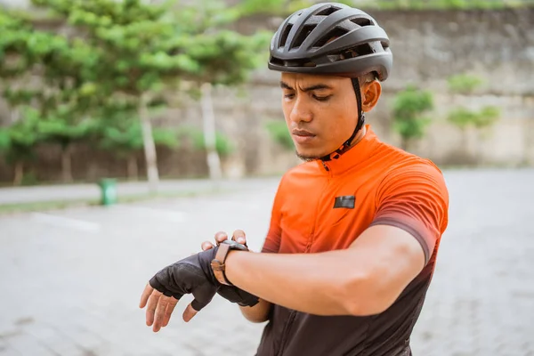 骑自行车的人在一个聪明的手表下检查他的锻炼进度 — 图库照片