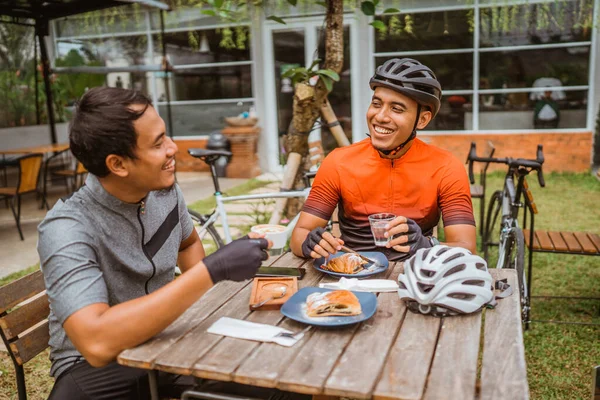 Dos ciclistas disfrutando del café en la cafetería después de montar — Foto de Stock