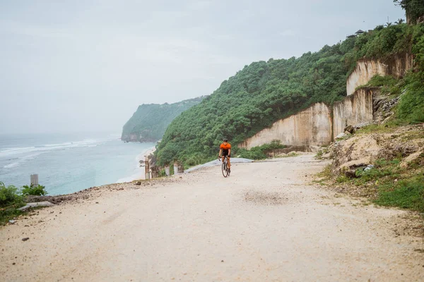 Road bike cyclist riding his bike on a cliff — Stock Photo, Image