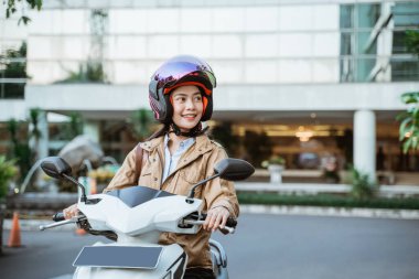 Motosiklet sürerken kask takan güzel bir kadın.