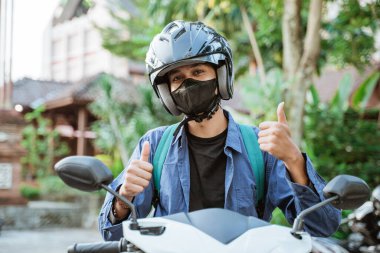Motosikletli, kask takan ve maskeli adam.