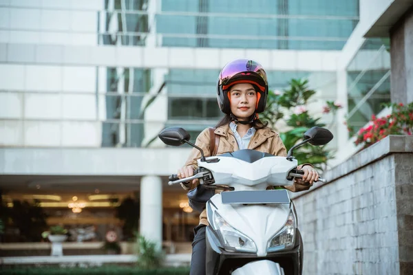 Motosiklet sürerken kask takan güzel Asyalı kadın.