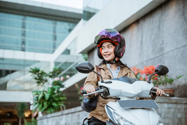 Улыбающаяся красивая женщина в шлеме во время езды на мотоцикле — стоковое фото