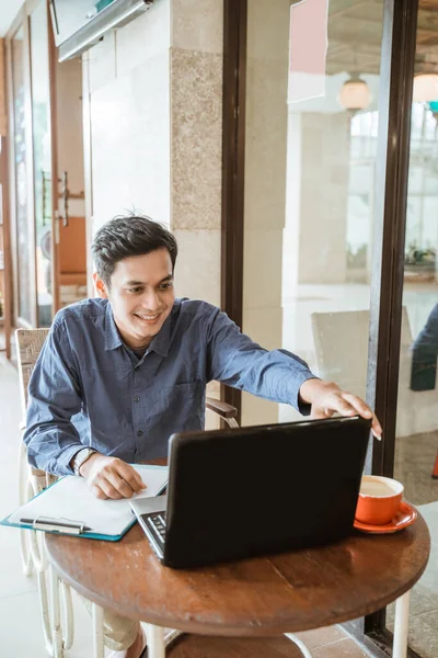 Azji młody człowiek działa za pomocą laptopa w co-working przestrzeni — Zdjęcie stockowe