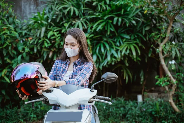 Woman with mask taking helmet before road riding with copyspace — Stock Photo, Image