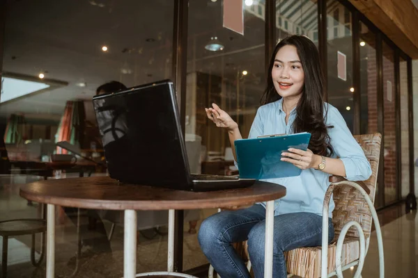 Mulher freelance trabalhando usando laptop e área de transferência durante a conferência on-line — Fotografia de Stock