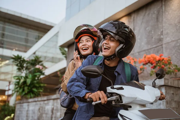 Un asiático hombre y mujer usando casco montando una motocicleta —  Fotos de Stock