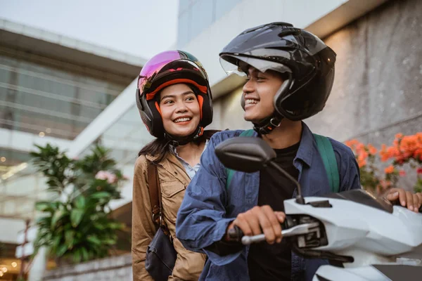 Un hombre y una mujer con cascos montados en una motocicleta — Foto de Stock