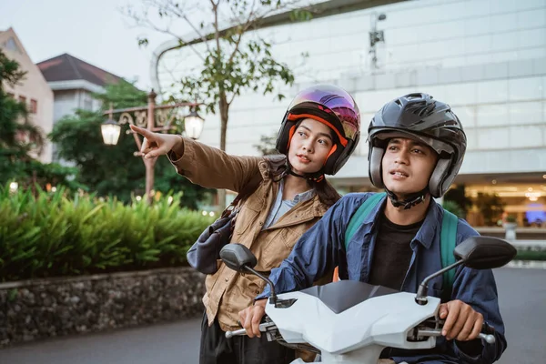 Kvinna bär hjälm peka finger med man på motorcykel — Stockfoto