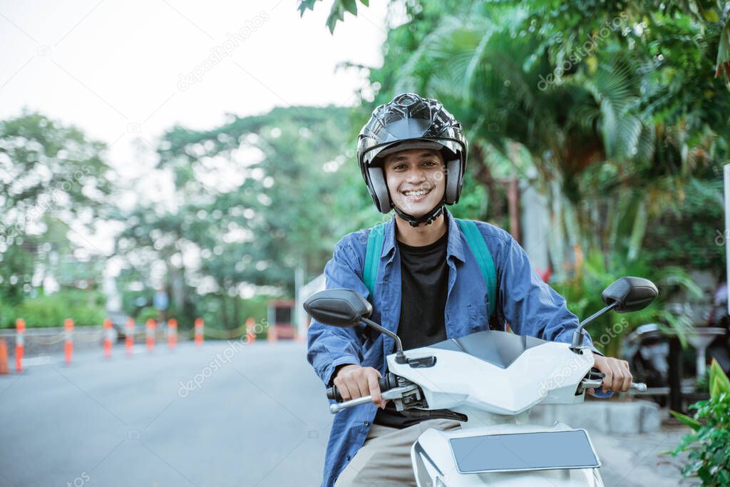 Asian man riding a motorcycle on the street