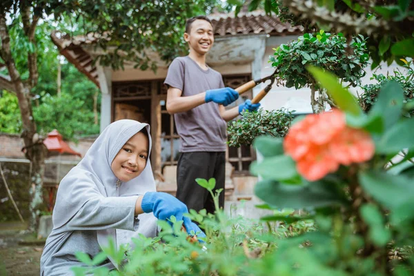 葉をトリミングするために植物はさみを使用して笑顔の男の子と女の子 — ストック写真