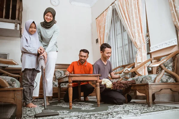 Padre, madre y dos niños juntos limpiando la habitación familiar — Foto de Stock