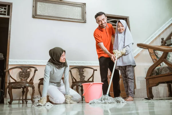 床を掃除するイスラム教徒のアジア系の父、母、娘 — ストック写真