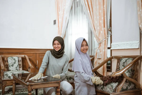 Madre en velo e hija limpiando casa juntos —  Fotos de Stock