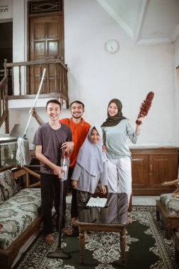 Baba, anne ve iki çocuk güzelce gülümsüyor.