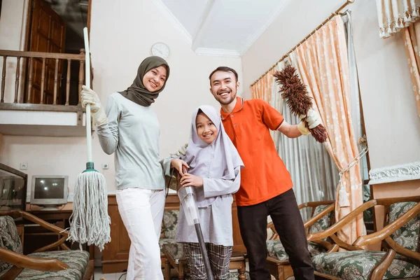 Mutlu Asyalı baba, anne ve kız temizlik aletleri tutuyor. — Stok fotoğraf
