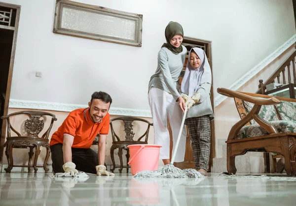 Πατέρας, μητέρα και κόρη καθαρίζουν το πάτωμα ενώ σφουγγαρίζουν — Φωτογραφία Αρχείου