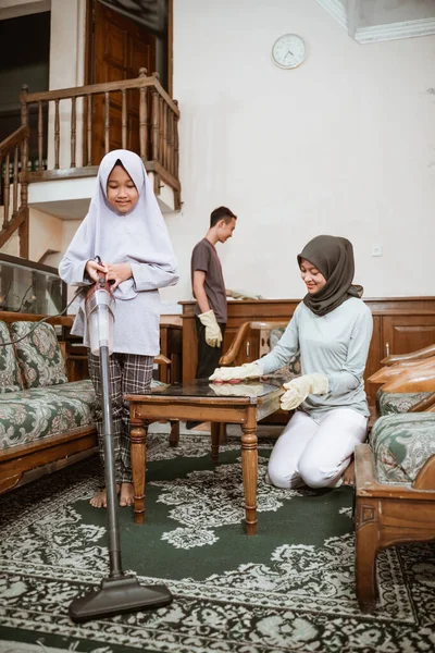 Gadis berjubah, kakak dan ibu membersihkan rumah bersama-sama — Stok Foto