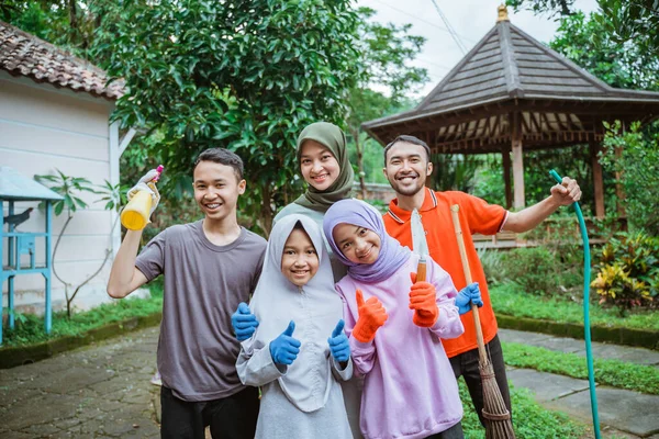 Ayah, ibu dan anak-anak tersenyum saat bersama berkebun — Stok Foto