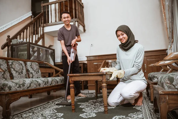 Ibu memakai jilbab dan anak membersihkan ruang keluarga — Stok Foto
