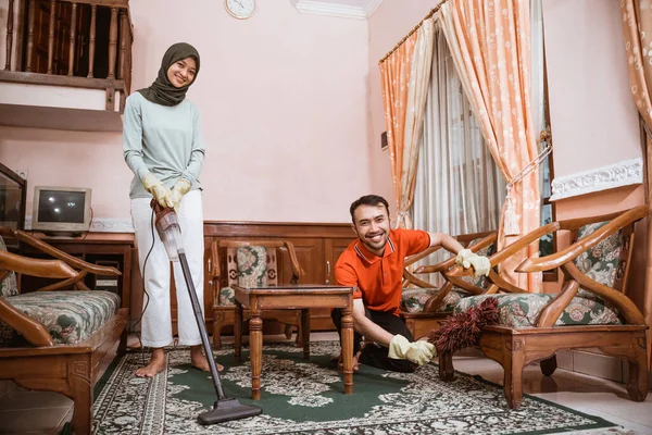 Ibu dan ayah tersenyum sambil membersihkan ruang keluarga — Stok Foto