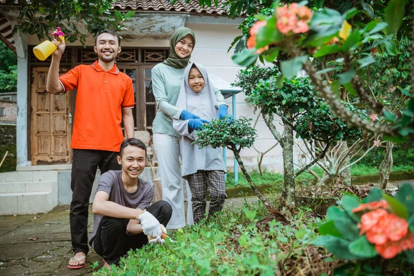 Keluarga bahagia tersenyum sambil berdiri di halaman sambil berkebun — Stok Foto