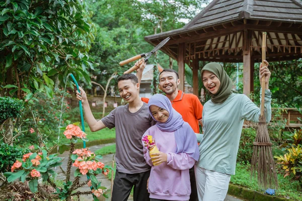 Emocionado pai, mãe e dois filhos ao jardinar com a família — Fotografia de Stock