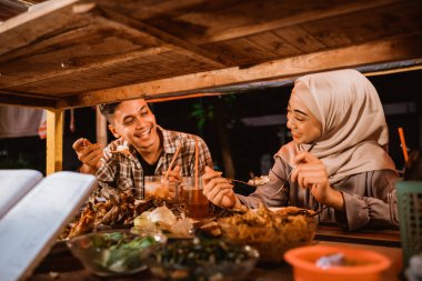 muslim man and woman enjoy having iftar dinner clipart