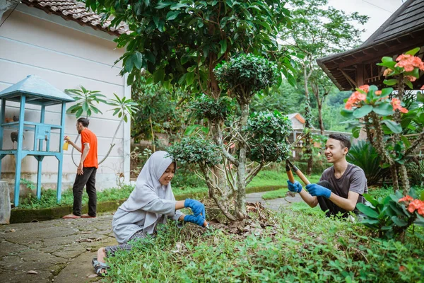 Keluarga bersama-sama mengurus tanaman hias di halaman — Stok Foto