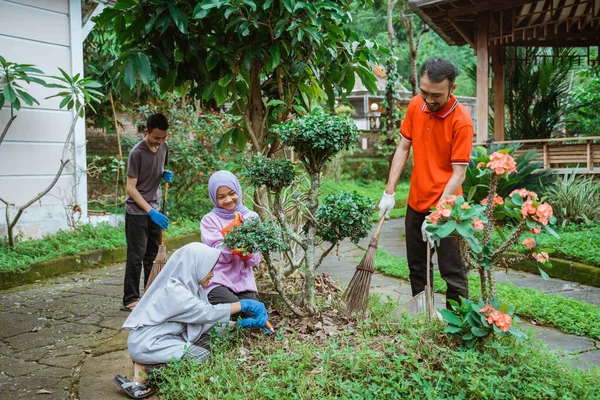 Kebersamaan keluarga membersihkan dan merawat tanaman hias — Stok Foto