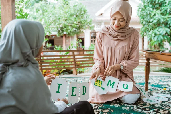 Mor och dotter bär hijab gör flaggkedja papper dekorationer — Stockfoto
