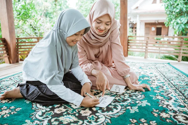 Terselubung ibu dan anak perempuan Asia membuat kartu ucapan eid mubarak — Stok Foto