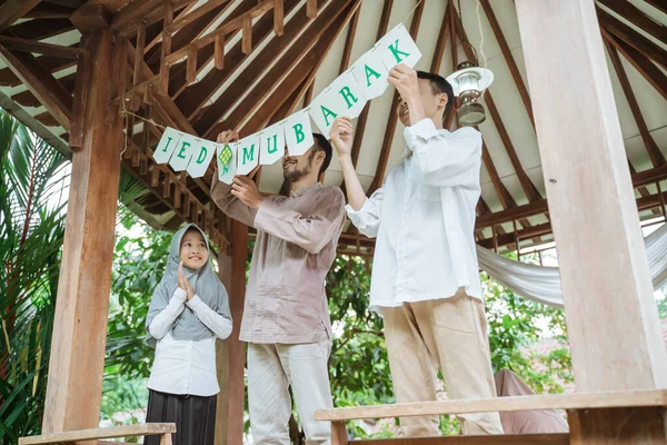 Ayah dan anak-anak menghias gazebo dengan rantai bendera — Stok Foto