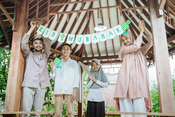 Muselman familj tillsammans sätta upp papper dekorationer i lusthus — Stockfoto